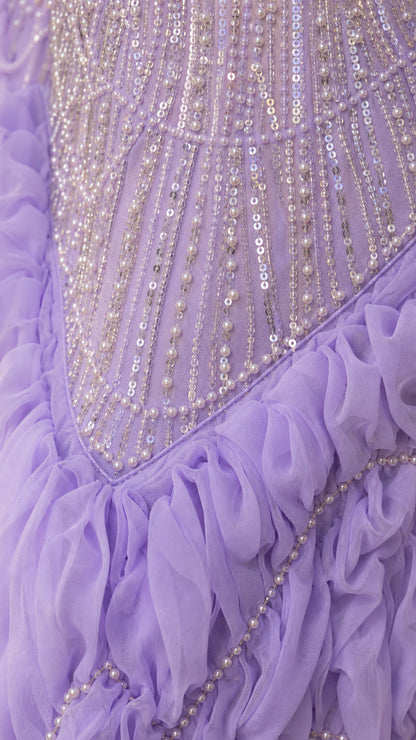 Close-up detail of lavender dress showing intricate beadwork, sequins, and ruffled fabric texture