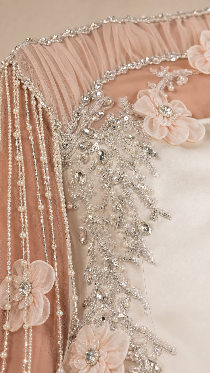 Close-up detail of sheer neckline, 3D floral blooms, and beaded pearl fringe