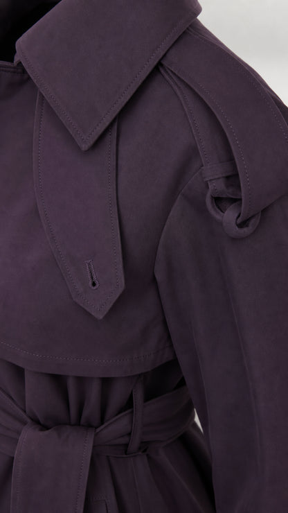 Close-up detail of deep purple trench coat shoulder epaulet tab and collar