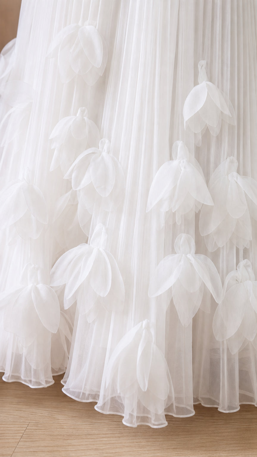 Close-up detail of 3d floral appliques on white tulle skirt hem