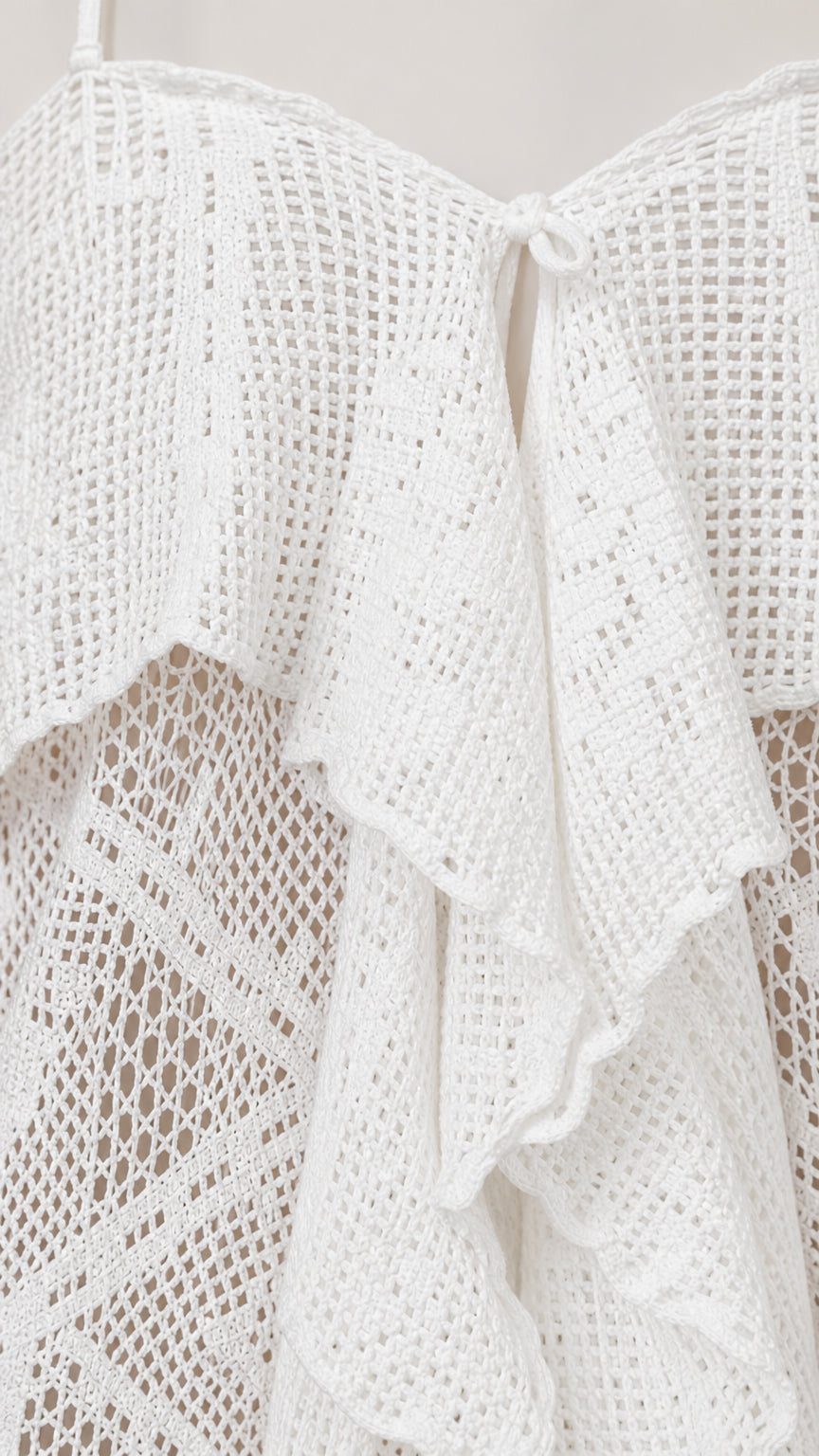 Close-up detail of white crochet lace texture and front ruffle
