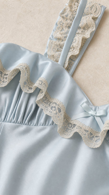 Close up of lace trim and ruffle strap detail on light blue dress