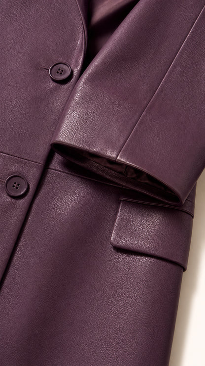 Close-up detail of faux leather texture, buttons, notch lapel, and pocket flap