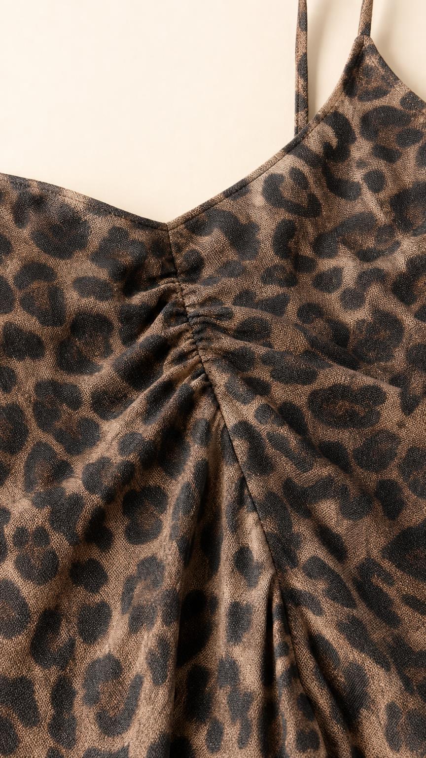 Close-up detail of fabric texture and V-neck ruching on leopard dress
