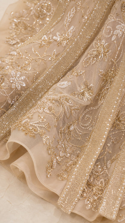 Close-up detail of metallic embroidery and beadwork on fabric