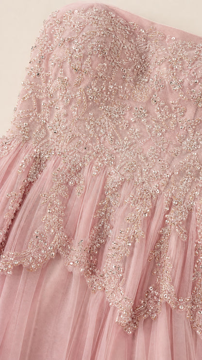 Close-up detail of shimmering beadwork, sequins, and scalloped peplum lace on dusty pink bodice