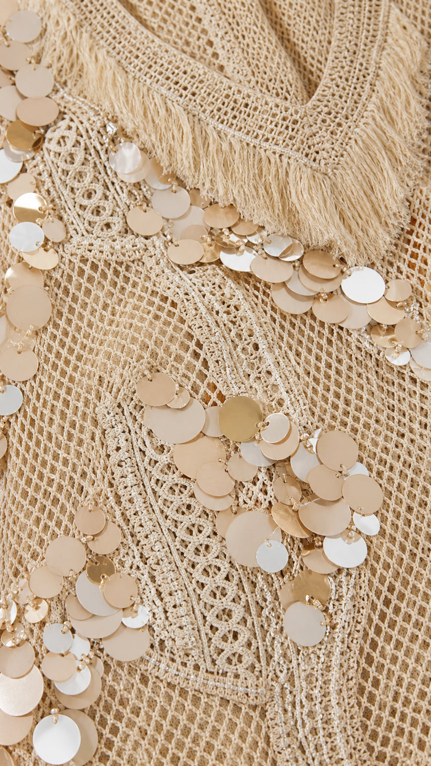 Close-up detail of mesh fabric, sequins, and fringe trim