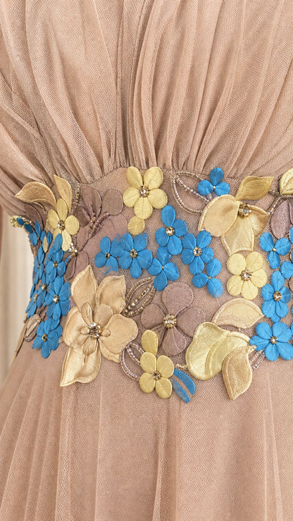 Close up of 3D floral embroidered waistband with blue and gold floral details