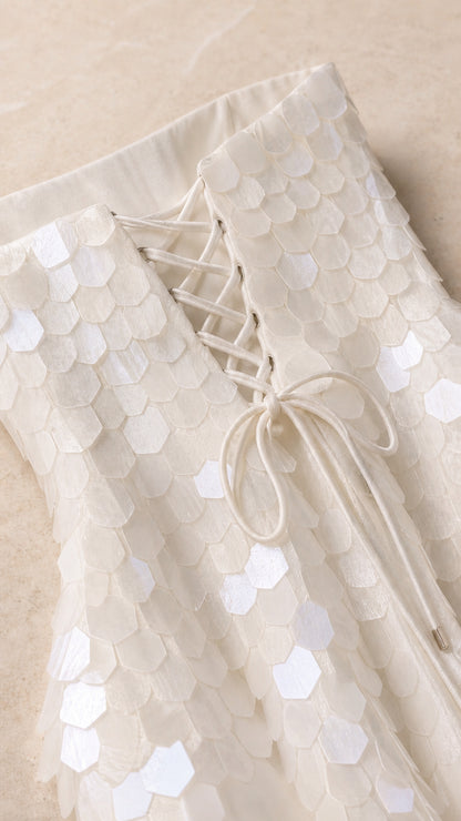 Close-up of fabric texture and lace-up back detail on white dress
