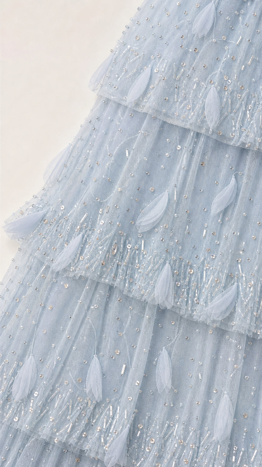 Close-up of fabric texture and beadwork on light blue dress