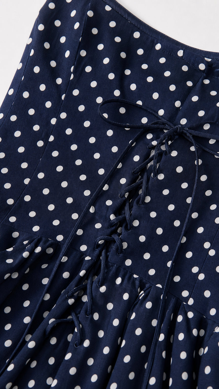 Close-up detail of the lace-up back on Navy polka dot dress