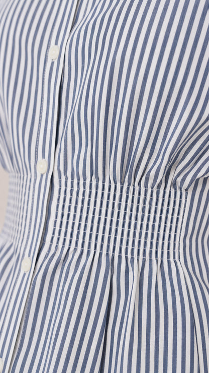 Close-up detail of blue vertical stripes and smocked waist construction