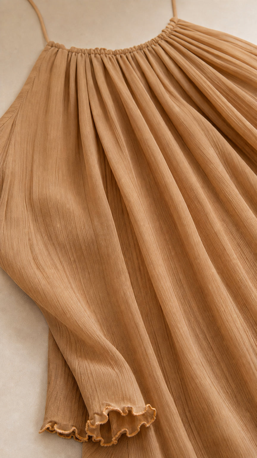 Close-up of camel pleated fabric texture and lettuce hem