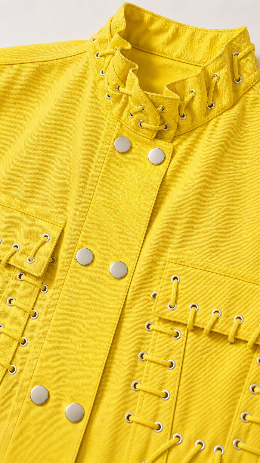 Close-up detail of yellow vest showcasing lace-up stand collar and metal snap buttons