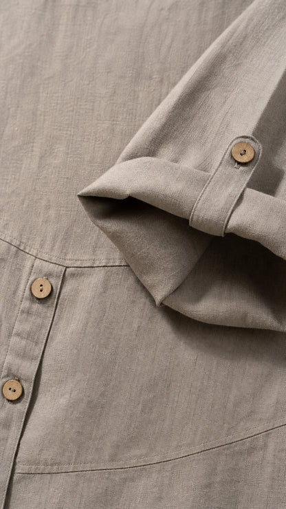 Close-up detail of fabric texture, side buttons, and sleeve cuff tab