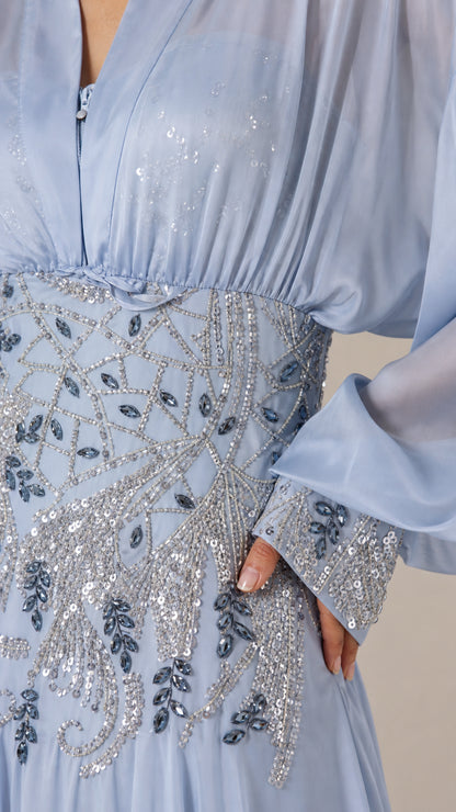 Close-up of beaded waist and sequin cuff details on light blue dress