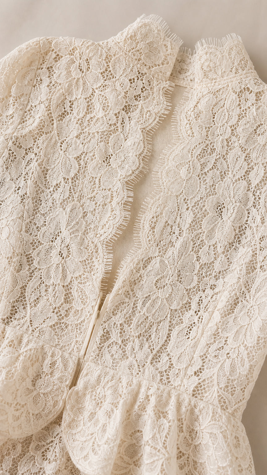 Close up texture of ivory floral lace fabric and scalloped eyelash edge