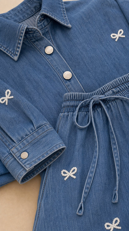 Close-up detail of blue denim shirt buttons and drawstring pants with bow embroidery