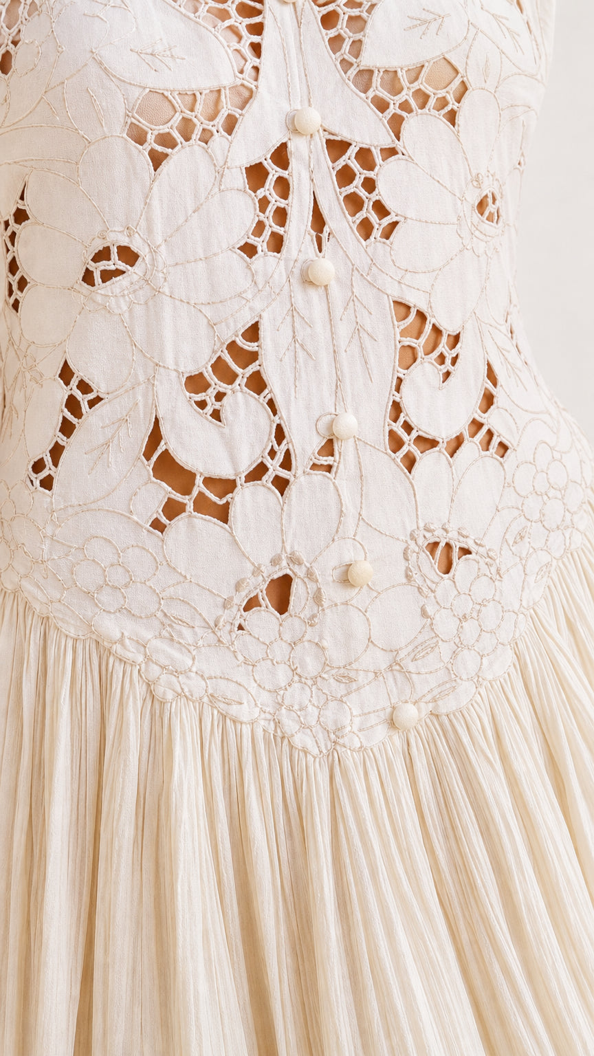 Close-up detail of crochet bodice and button back on white maxi dress