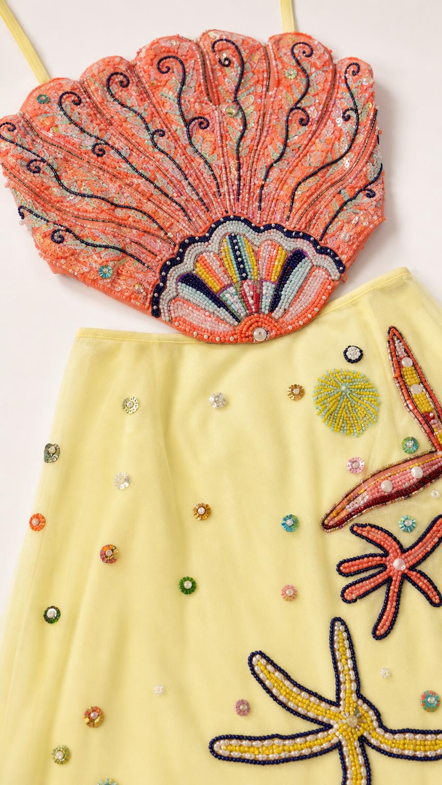 Close-up detail of beaded seashell crop top and starfish maxi skirt