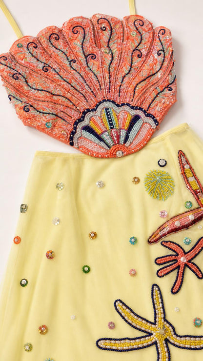 Close-up detail of beaded seashell crop top and starfish maxi skirt