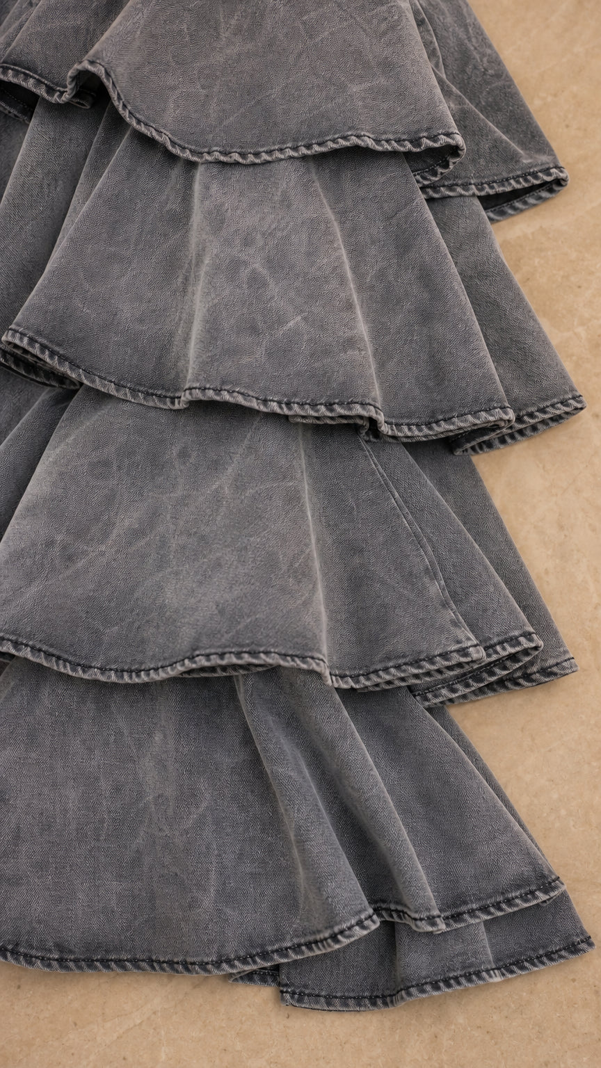 Close up texture detail of grey washed tiered ruffle hemlines