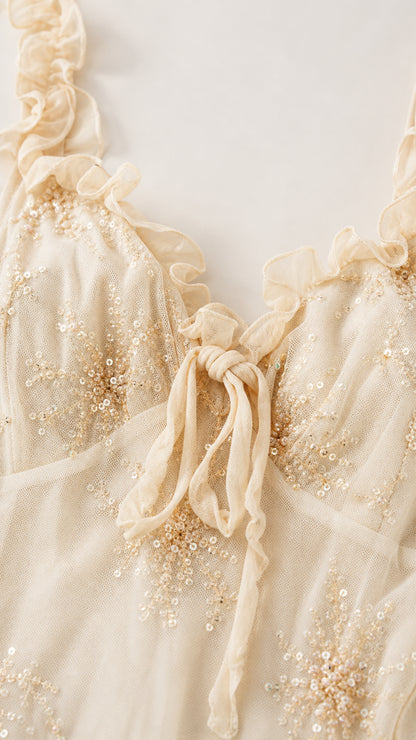 Close-up of cream dress sequin and tie-strap details