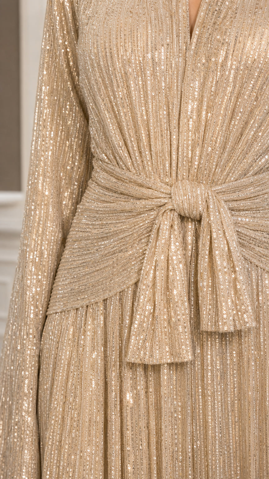 Close up of shimmering pleats and knotted waist tie detail