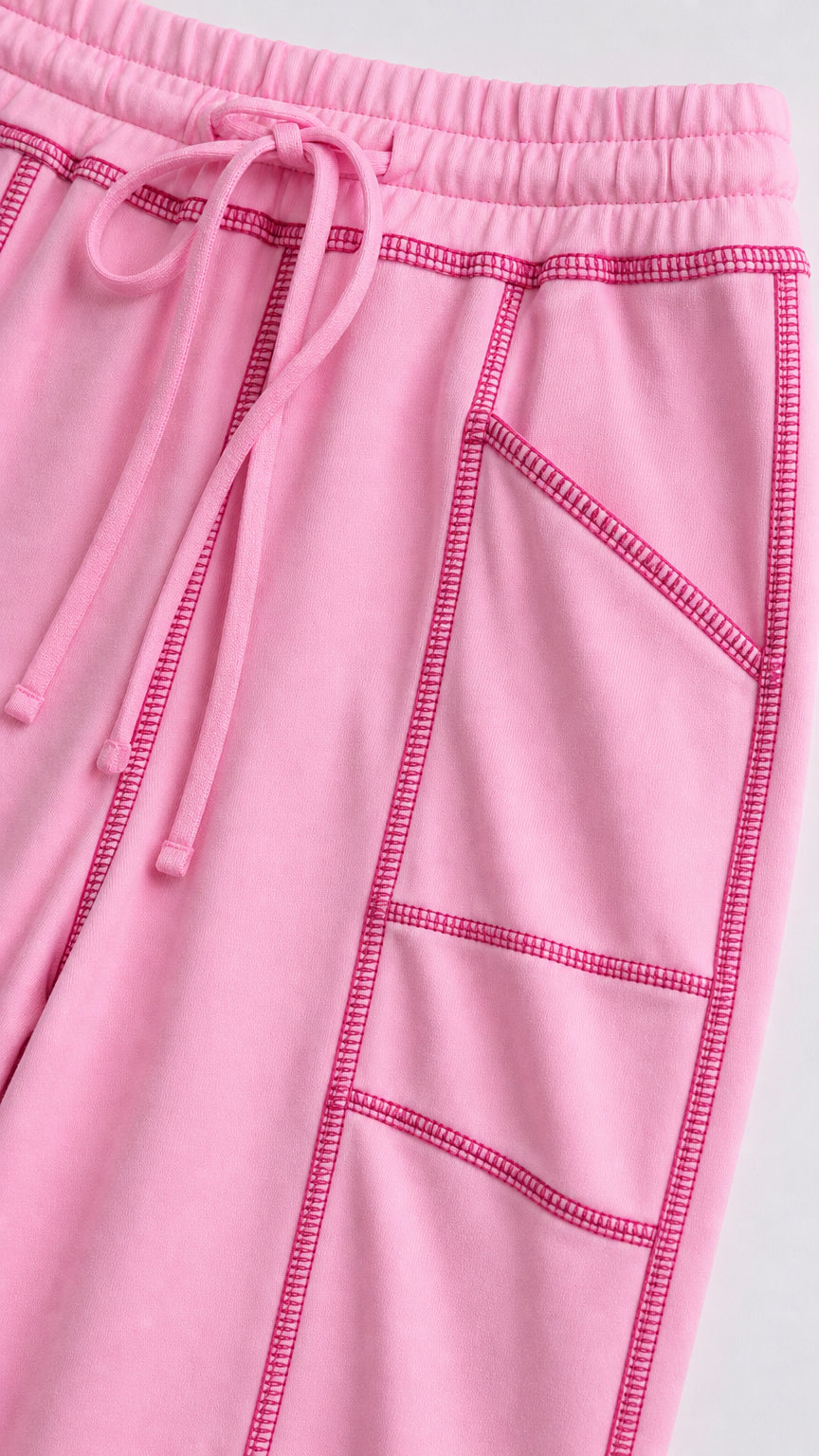 Close-up detail of pastel pink drawstring waist and contrast stitching pockets