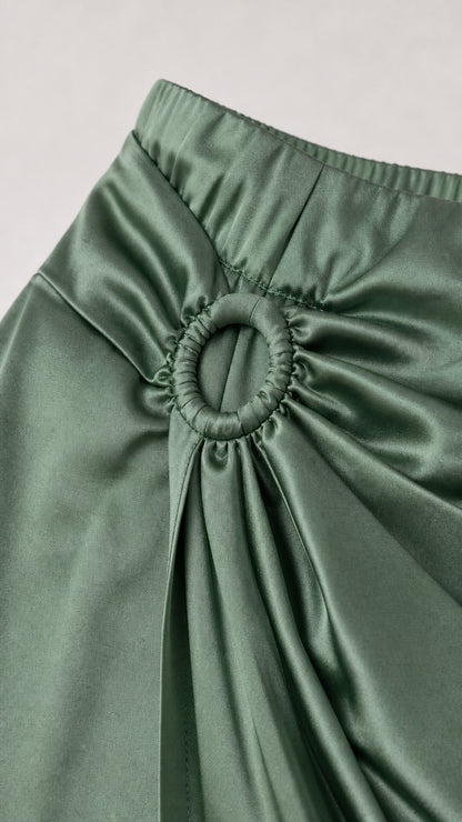 Close-up detail of the gathered ring buckle and waist ruching on the satin skirt