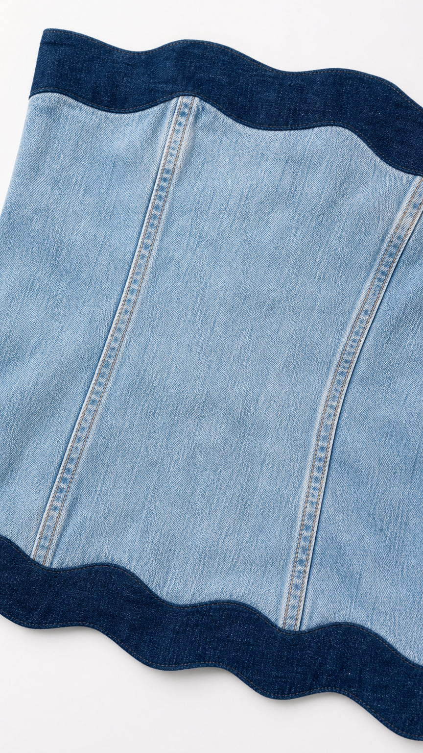 Close-up detail of contrast dark blue stitching and scalloped trim