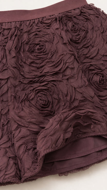 Close-up detail of the dimensional rose applique fabric and hemline