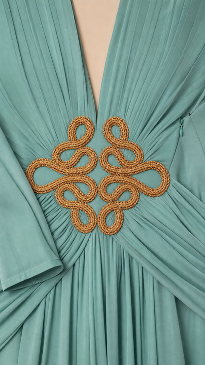 Close up of gold cord braided waist motif and pleated bodice