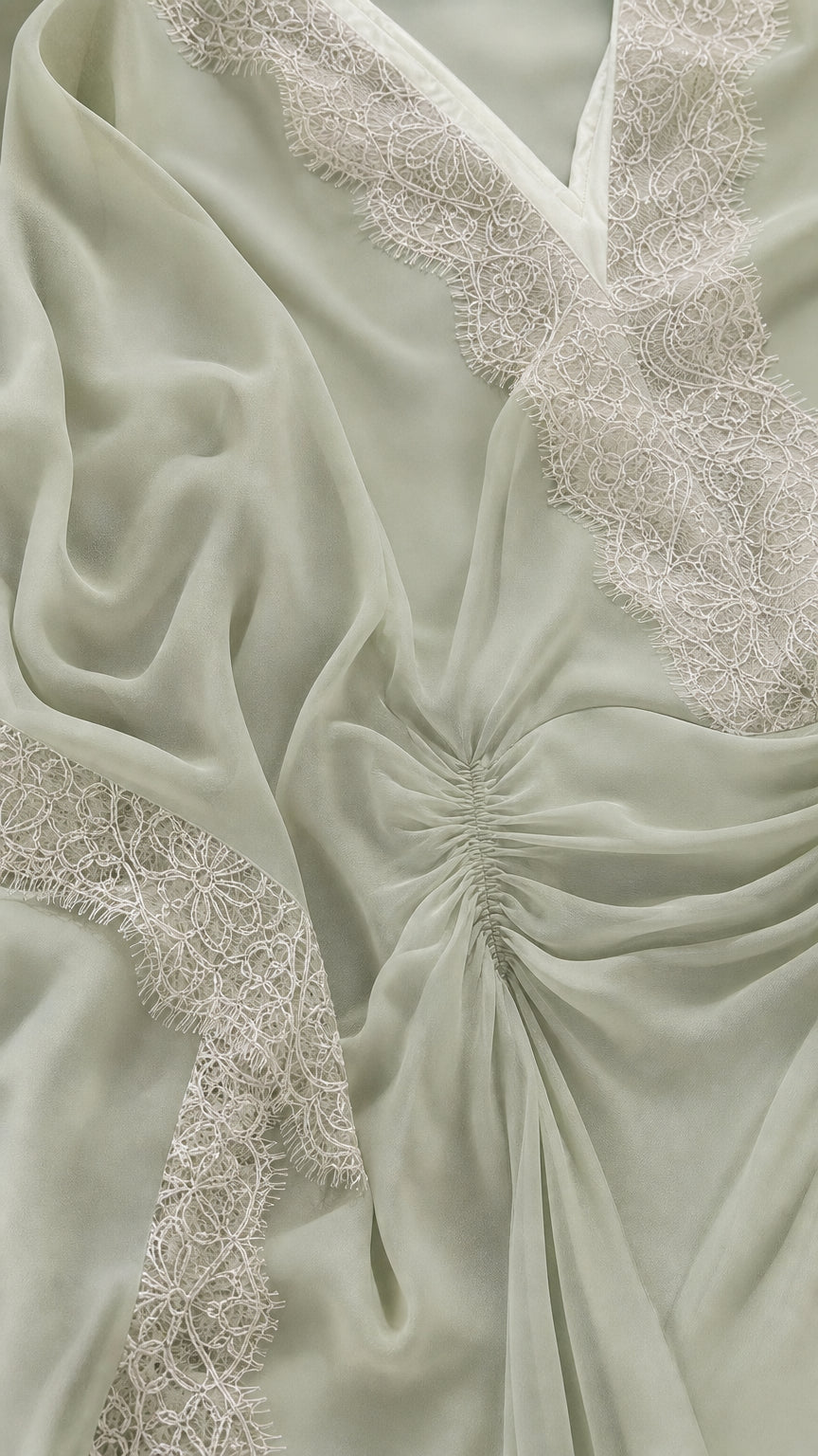 Close-up detail of lace trim and gathered front on sage green kaftan
