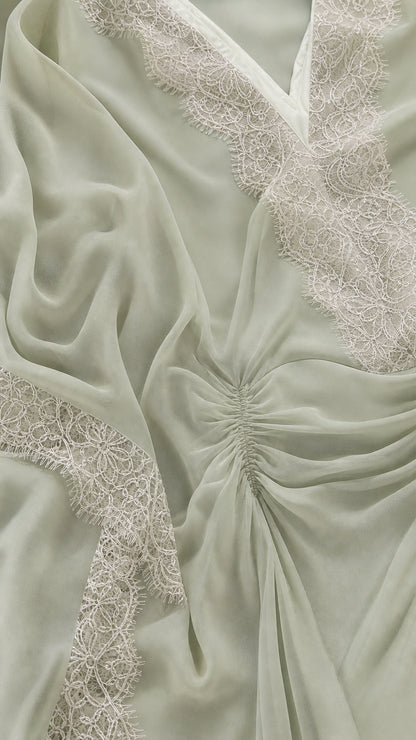 Close-up detail of lace trim and gathered front on sage green kaftan