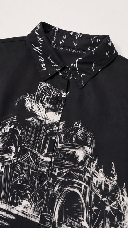 Close-up detail of turn-down collar with script pattern and architectural print on black fabric