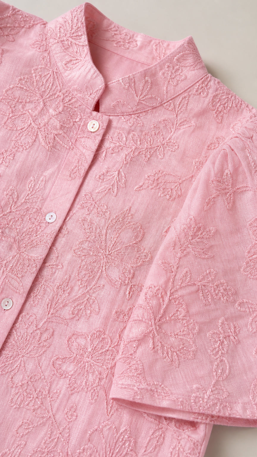 Close-up detail of pink stand collar and intricate floral embroidery on short-sleeve shirt