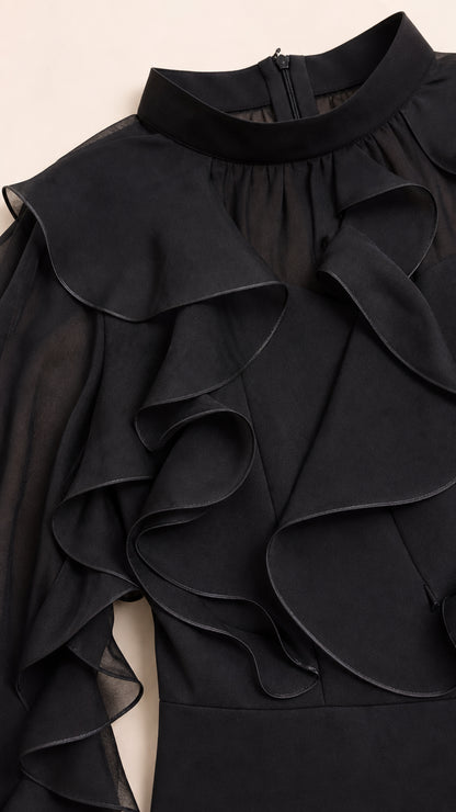 Close-up detail of mock neck and layered ruffles on black dress