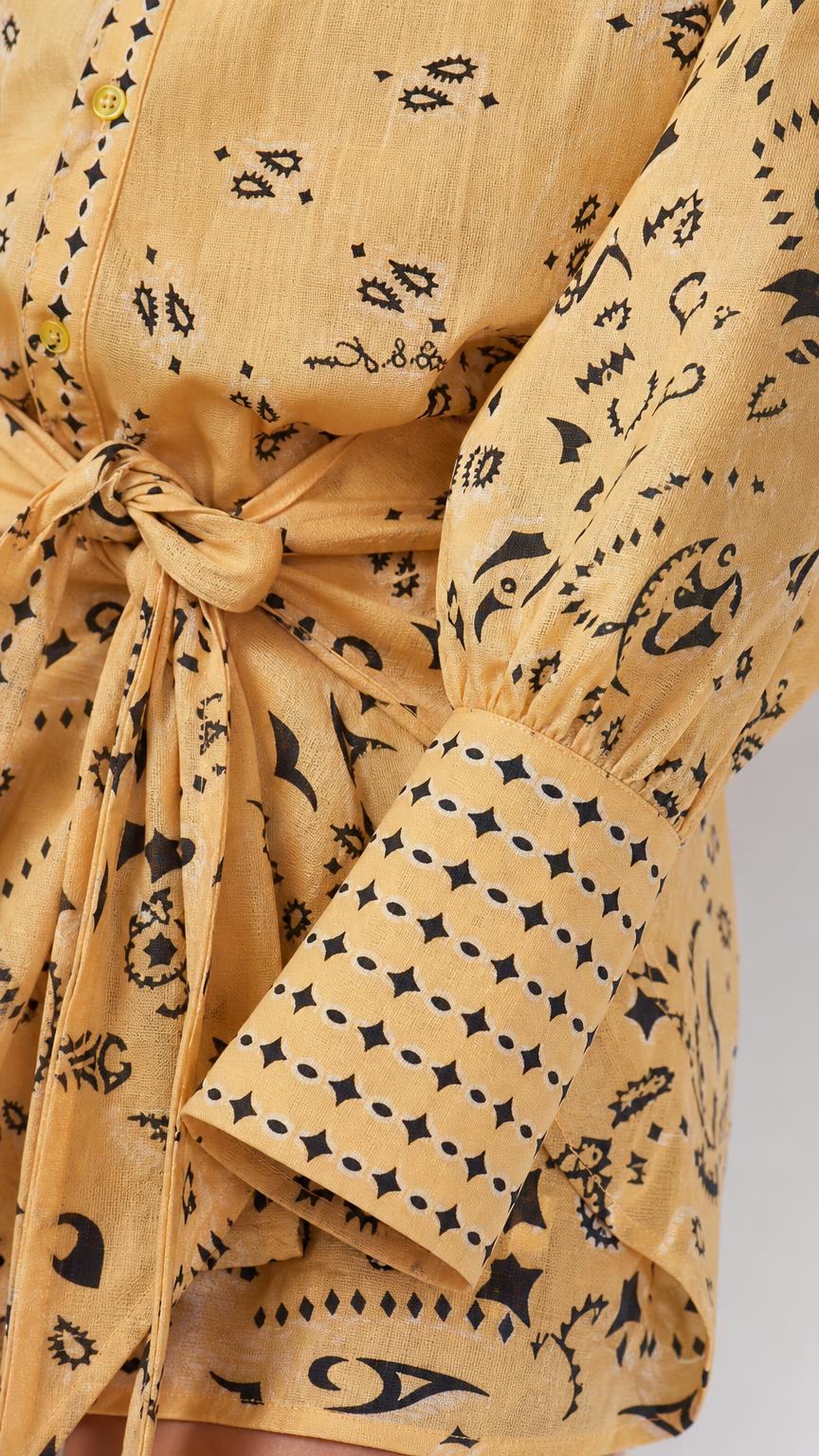 Close-up of the printed fabric, button detail, and cuffed sleeves