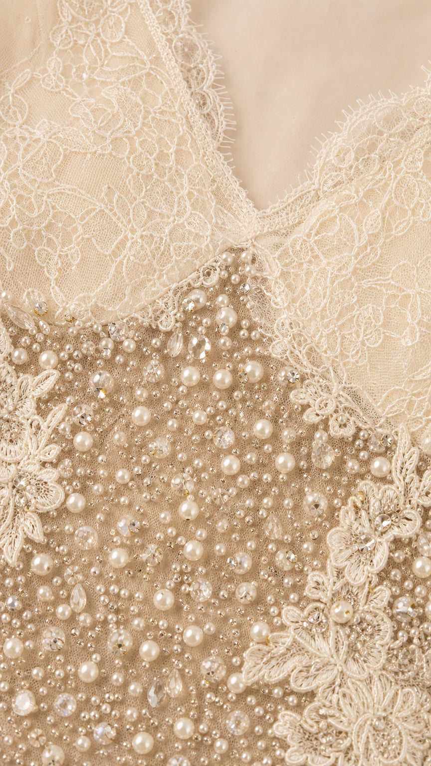 Close-up detail of delicate eyelash lace neckline and pearl bead embellishments