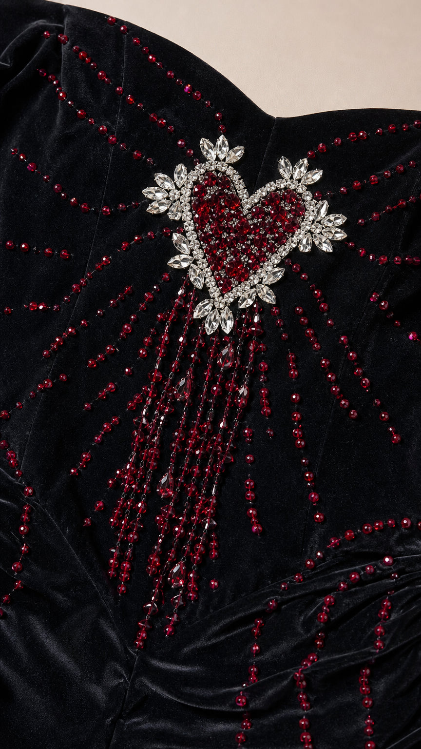Close-up detail of crystal rhinestone and beaded heart embellishment on black velvet