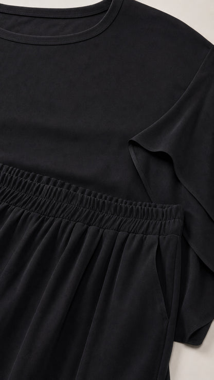 Close-up detail of crewneck, split-sleeve, and elastic waistband on black set