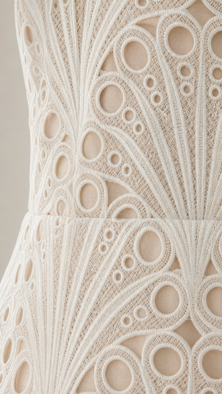 Close-up detail of the intricate circular embroidered lace fabric and texture