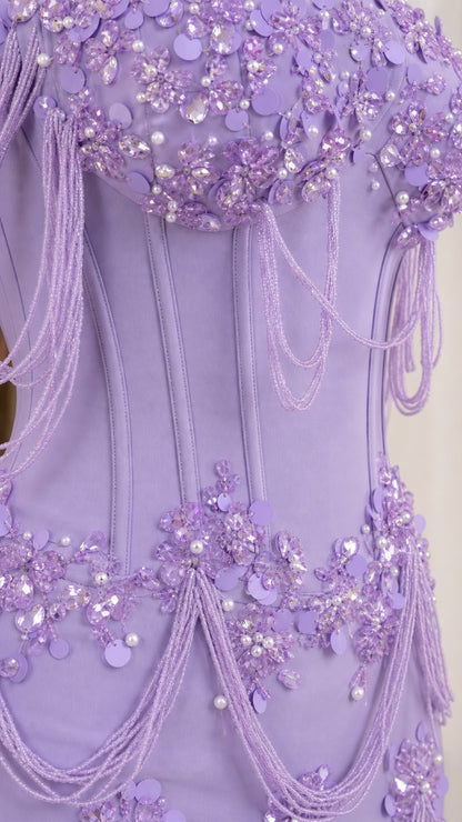 Close-up detail of structured bodice, floral beadwork, and draping