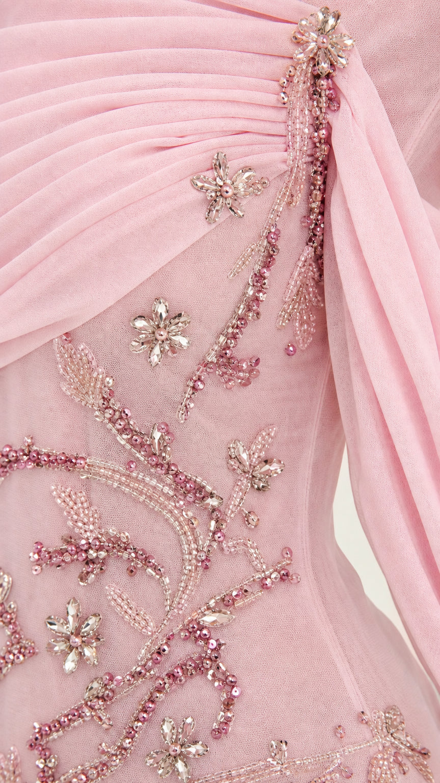 Close-up detail of blush pink draped chiffon bodice and intricate floral beading