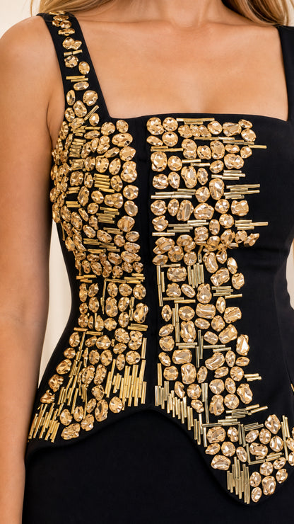 Close-up detail of golden beading, crystal stones, and embroidery on the bodice