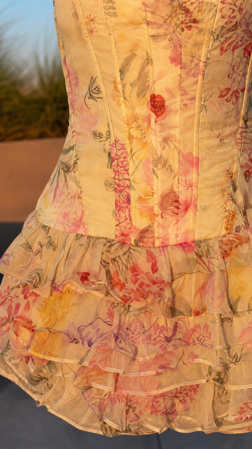 Close-up detail of structured bodice and ruffled hem on yellow floral dress