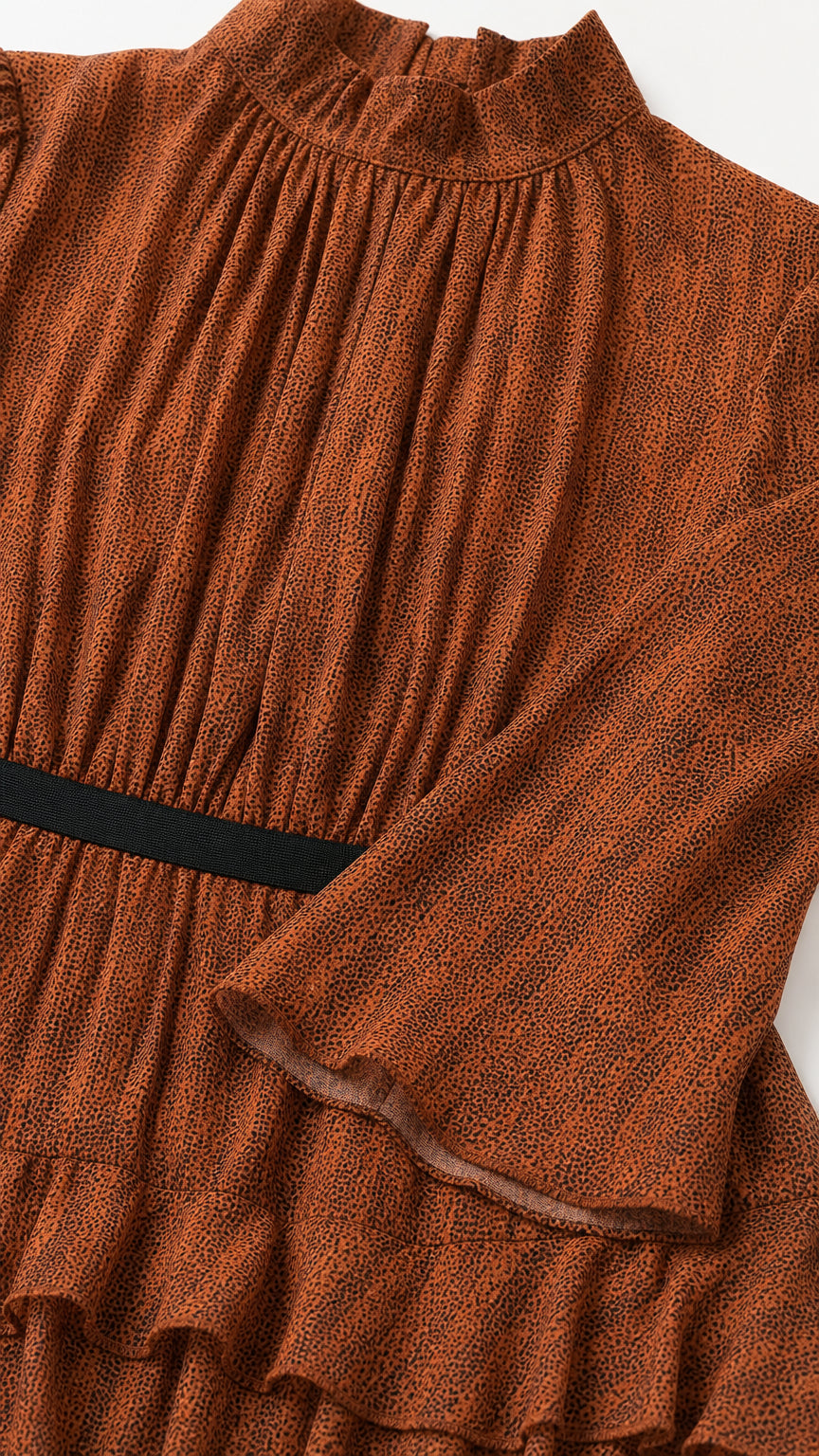 Close-up detail of textured fabric, mock neckline, and contrast waistband on Rust Brown dress