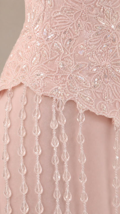 Close up of blush pink sequin lace bodice with dangling bead trim