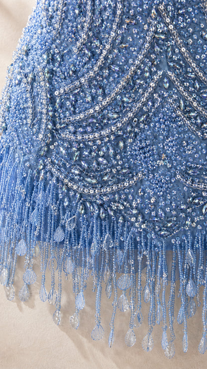 Close up of blue beadwork and fringe hem detail